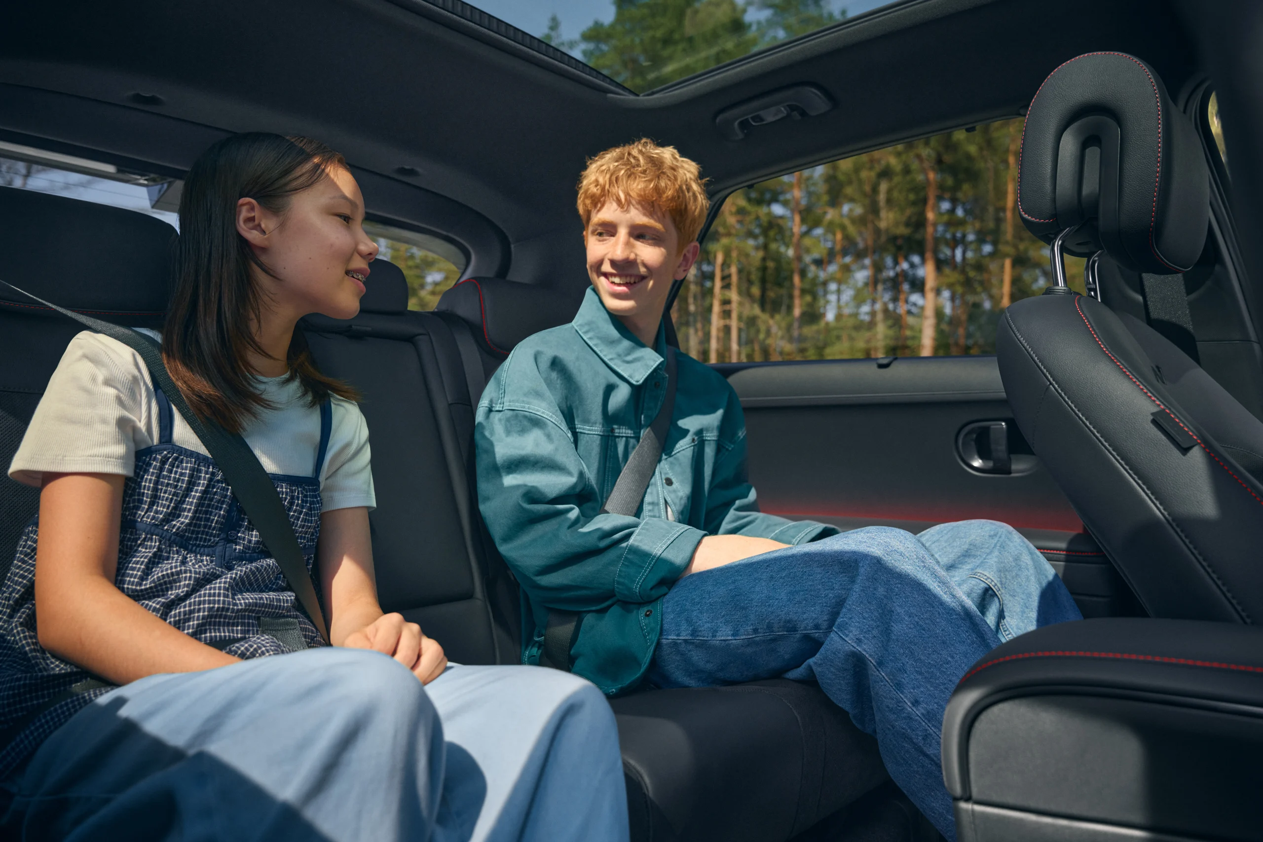 To personer i baksetet i Hyundai IONIQ 5 under glasstak