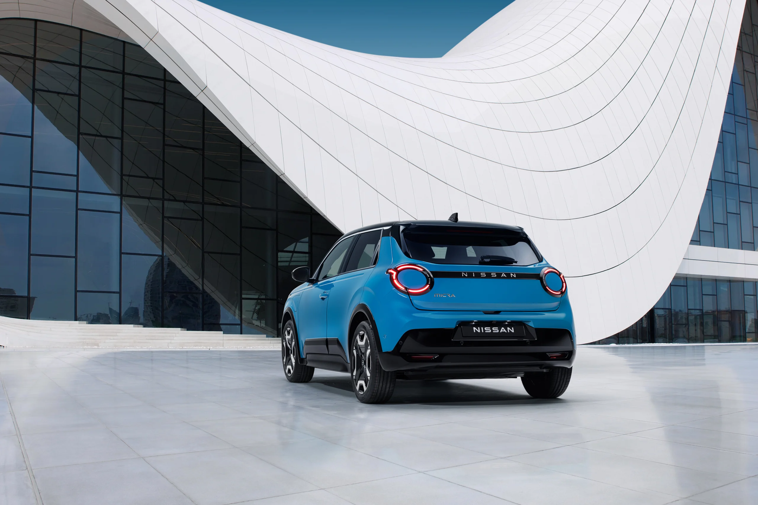 Micra i Gear Blue foran en hvit og blå fasade