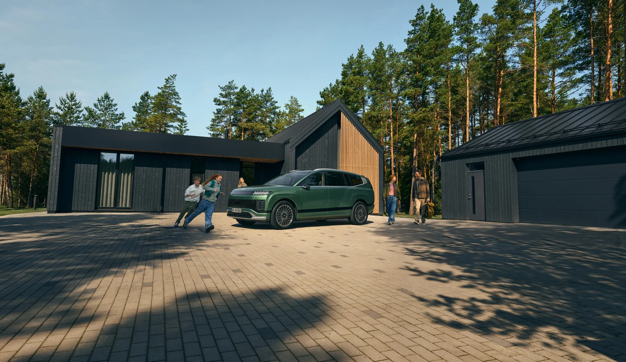 Hyundai IONIQ 9 utenfor et hus i skogkanten