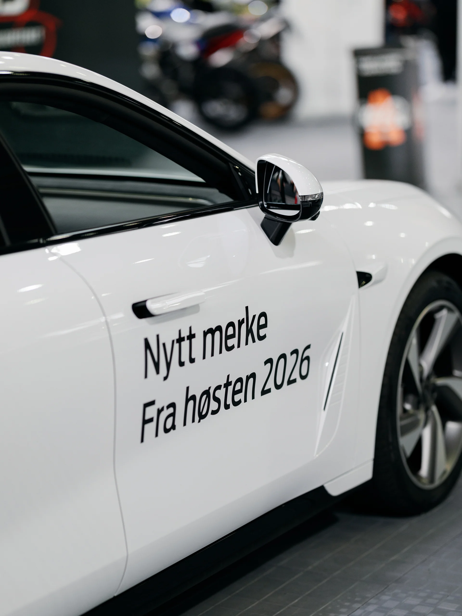 Exlantix ES sett fra siden på messestanden, med teksten Nytt merke fra høsten 2026 på døra