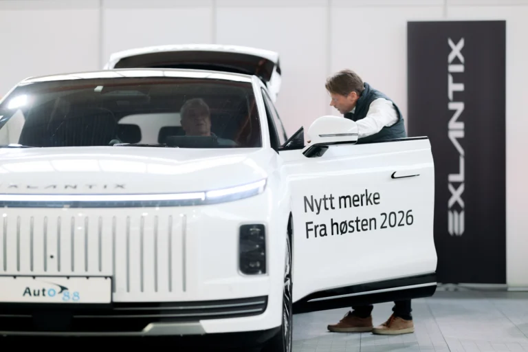 Selger fra Auto 8-8 ved den åpne døra på Exlantix ET, med en besøkende i førersetet og Exlantix-banneret bak
